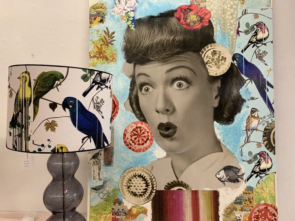 Lampenschirm mit Vogelmotiv neben einer Collage im Atelier