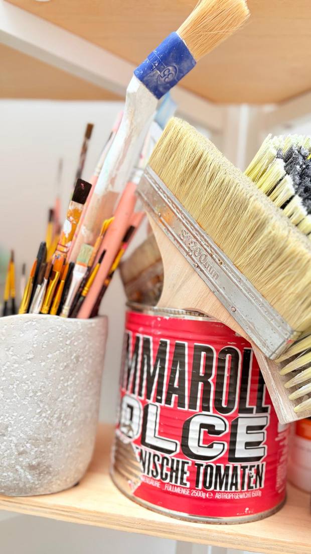 Pinsel in Dosen und Bechern im Atelier